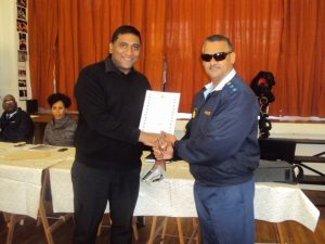 CIDC Executive Manager, Abdul Kerbelker receiving the award from Colonel Joseph for Exceptional Partnership Policing 2013/2014 FIN year. 